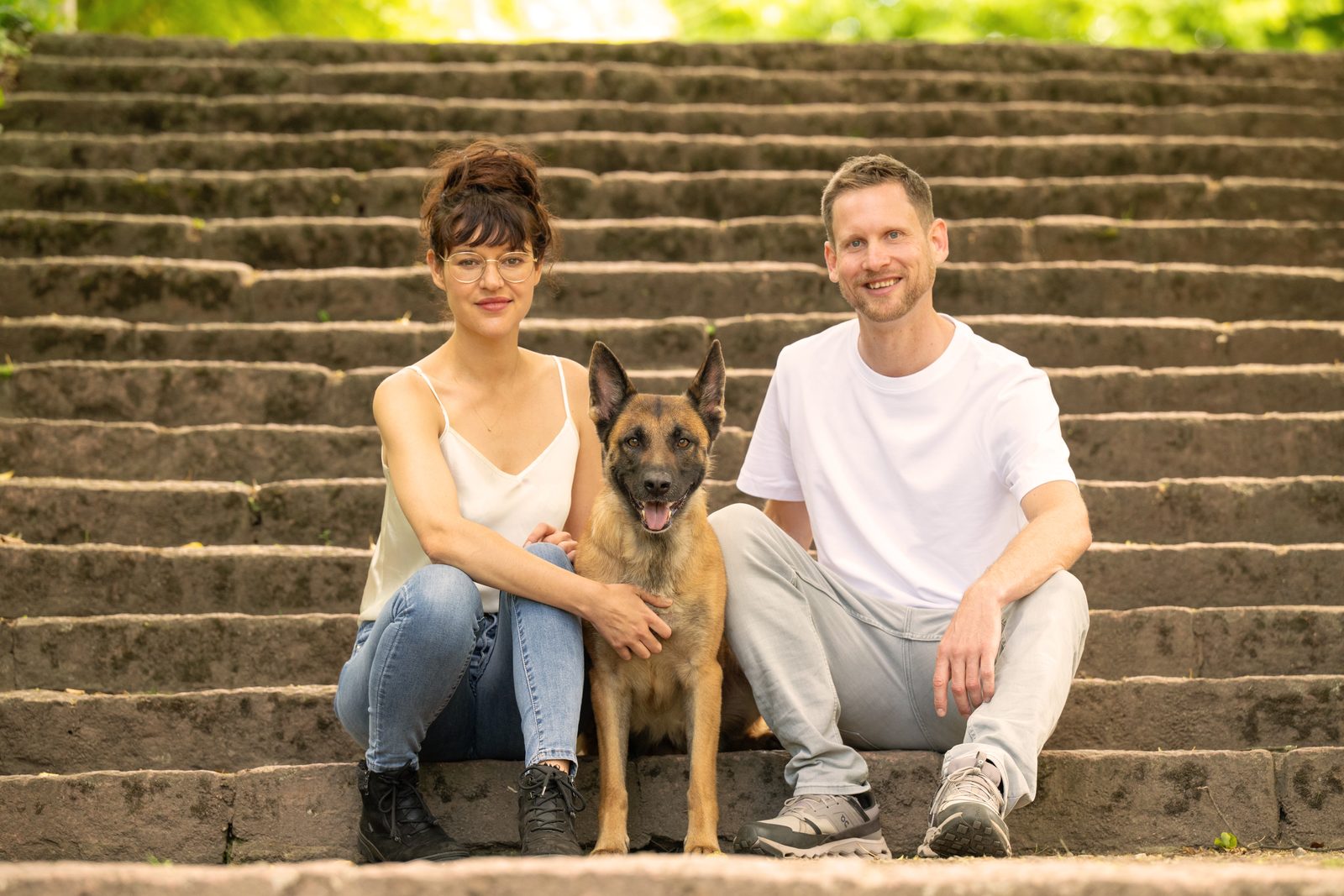 Clemens, Ronja und ihre Schäferhündin Mali sitzen gemeinsam auf einer Treppe